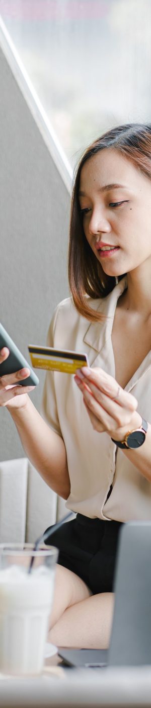 Asian woman using laptop and online shopping credit card at a co Asian woman using laptop and online shopping credit card at a coffee shop